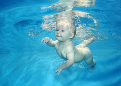Новорожденный плавает под водой