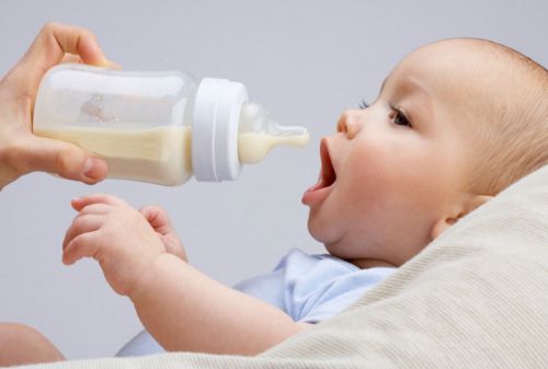 Младенца кормят из бутылочки