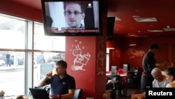 Эдвард Сноуден в выпуске новостей в кафе аэропорта Шереметьево. Москва, 24 июля 2013 года.